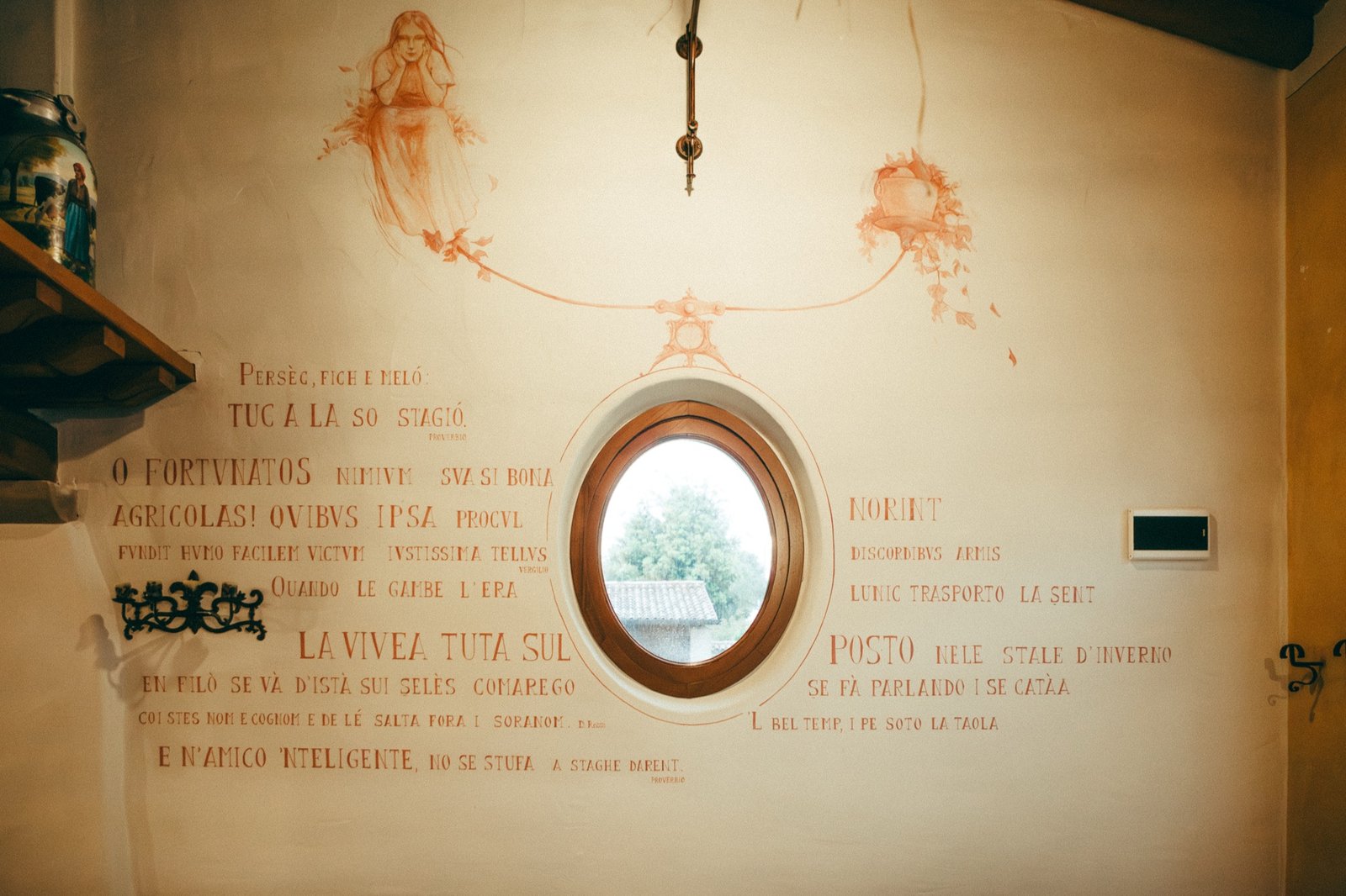 Il muro principale della sala, con i quattro testi dipinti attorno alla finestra ovale.